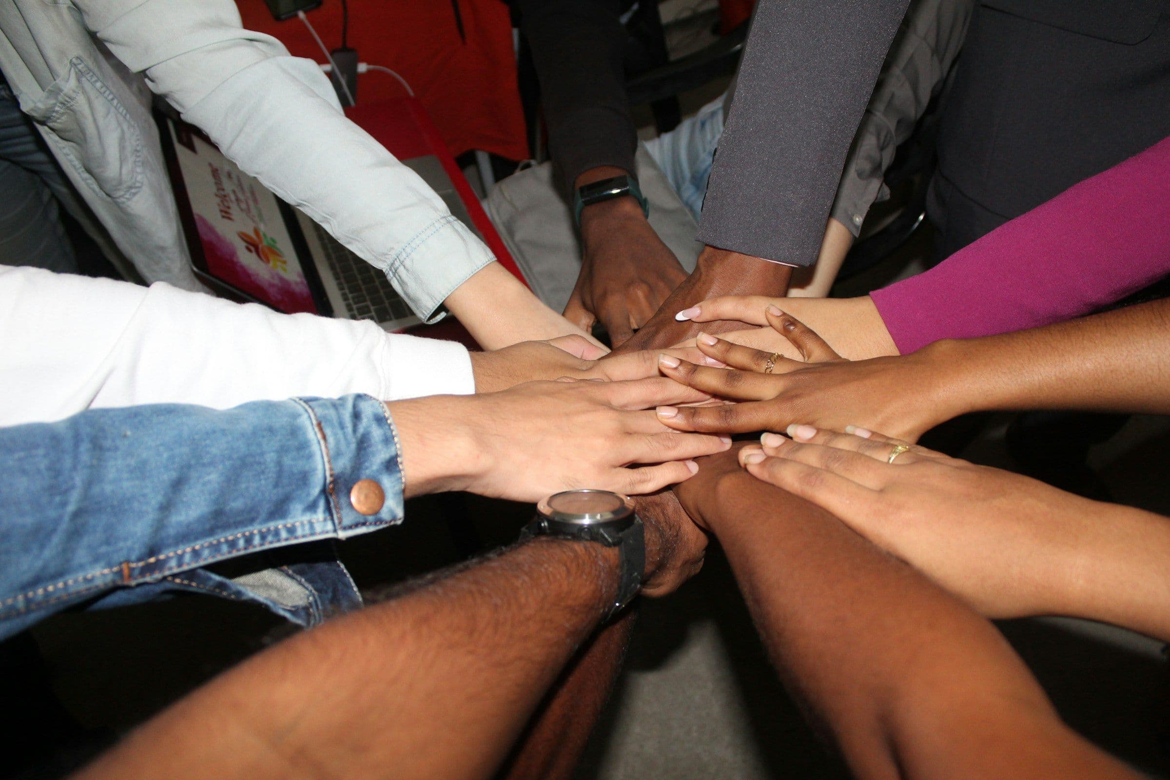 Hands of a team stacked together in the centre of a circle
